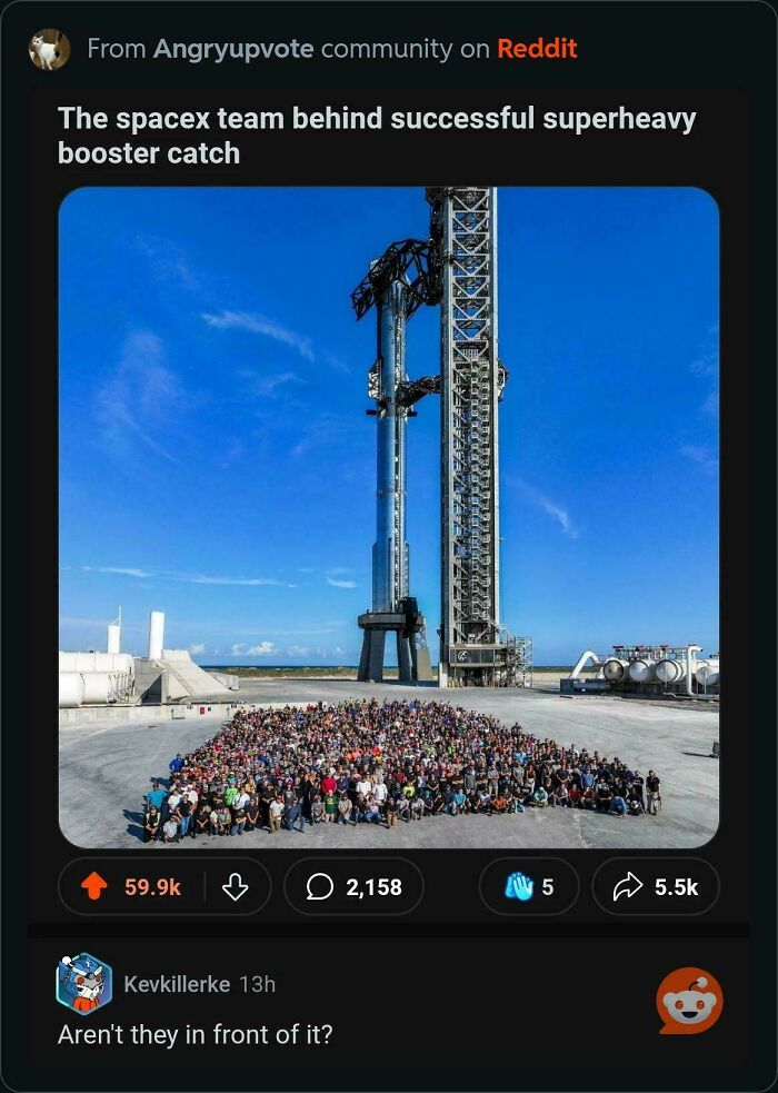 Large group photo of SpaceX team with rocket launch tower against clear blue sky, Internet responses trending on Reddit.