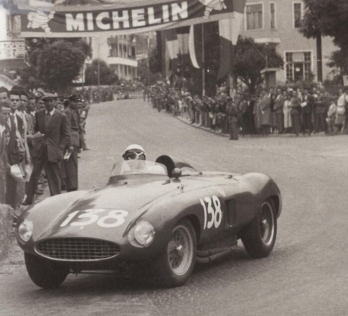Vintage race car numbered 138 speeding through a street race with crowds watching, daily life across the globe in the 50s