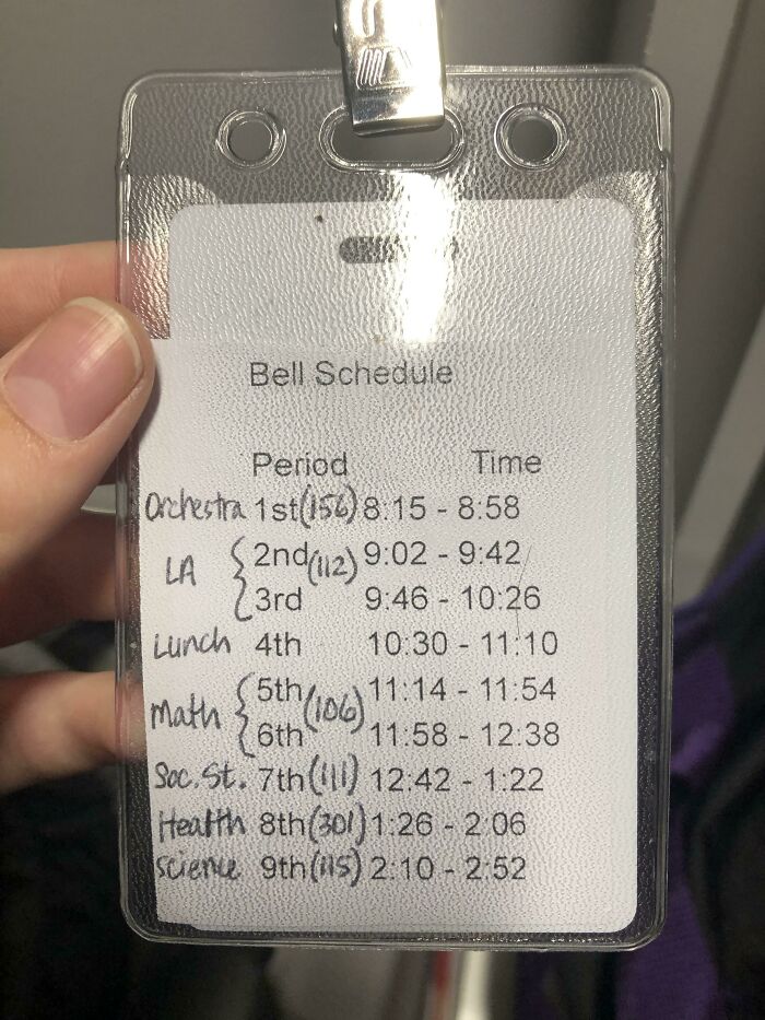 Handwritten school bell schedule with periods and times on a laminated ID card showing school details.