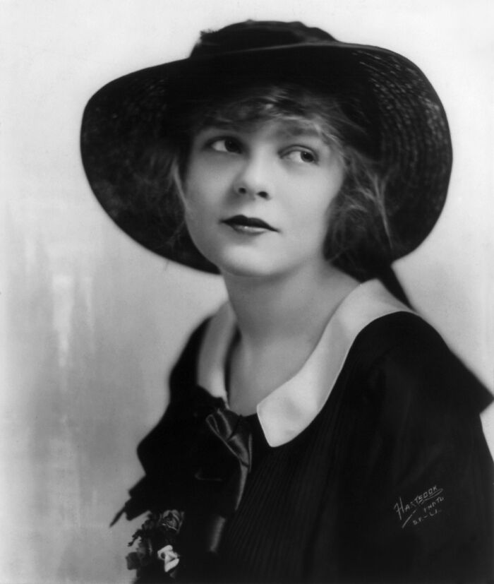 Vintage black and white portrait of a woman in a hat showcasing timeless beauty and century-old elegance.