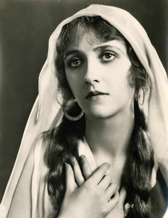 Vintage black and white portrait of a woman showcasing timeless beauty and classic feminine elegance in century-old photos.