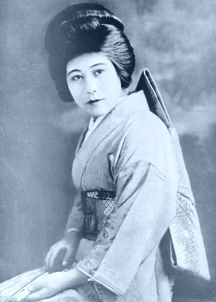 Vintage portrait of a woman in traditional attire showcasing timeless beauty from century-old photos collection.