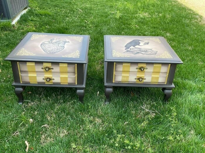 Two custom furniture flipping pieces with intricate artwork on tabletops and striped drawer fronts on grass outdoors.