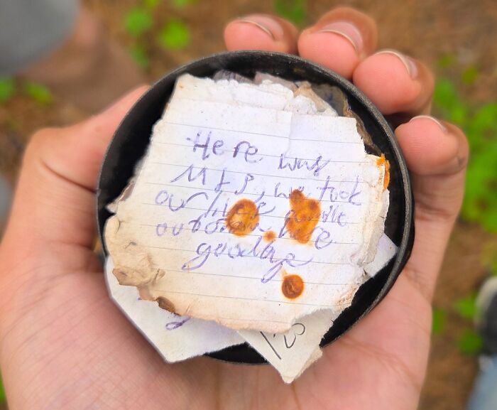 Hand holding a rusty, stained note found in the forest, one of the creepy and terrifying things discovered outdoors.