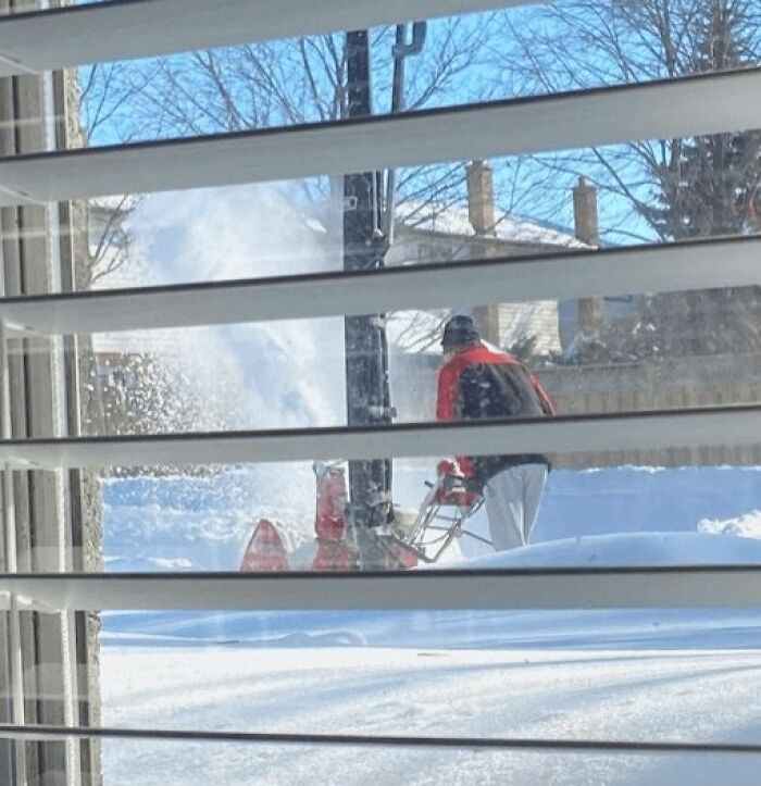 Person using a snowblower outside on a clear day, showcasing wholesome people and animals making the world better.