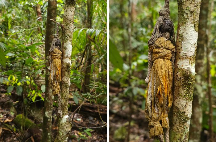 Creepy and terrifying forest find of a weathered, hanging rope doll tied to a tree in dense woodland.