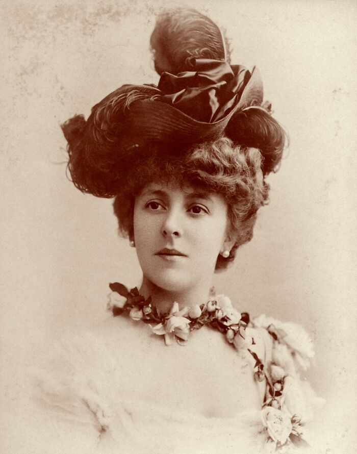 Vintage portrait of a woman with an elaborate hat and floral accessories, representing courtesans who became power players.