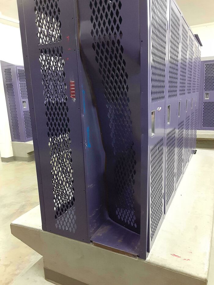 Locker space in a school gym with damaged and bent metal lockers showing unequal school facilities conditions.