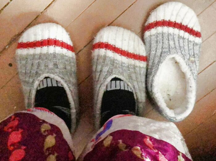 Two feet wearing matching slippers next to a single slipper, showing a real-life glitch in the matrix moment.