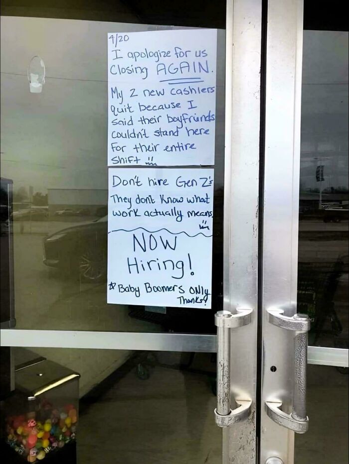 Handwritten sign on a glass door humorously discussing hiring Baby Boomers over Gen Z workers and work attitudes.