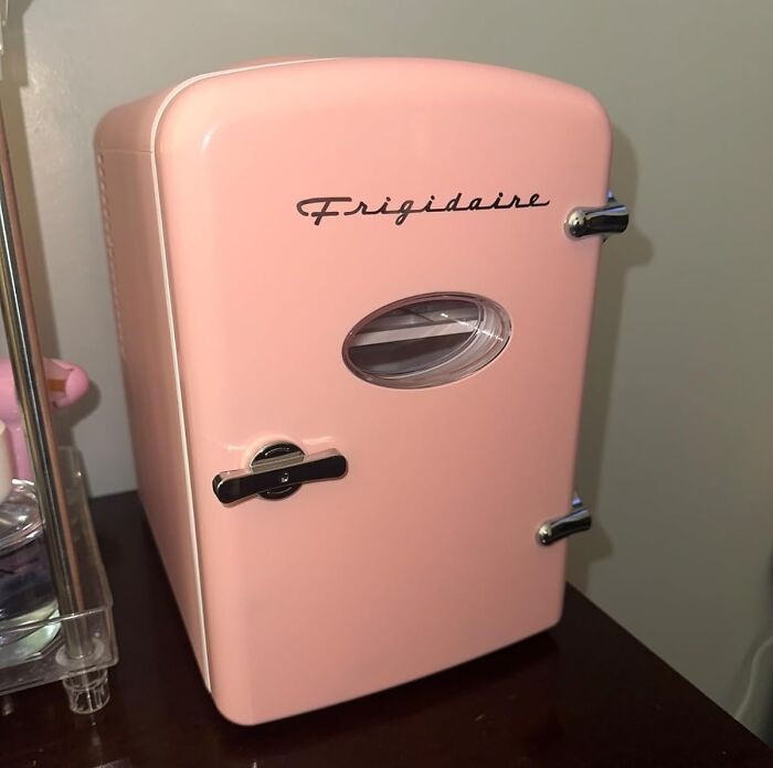Pink Frigidaire mini fridge on a dark table, showcasing one of the 20 under-the-radar finds that understood the assignment.