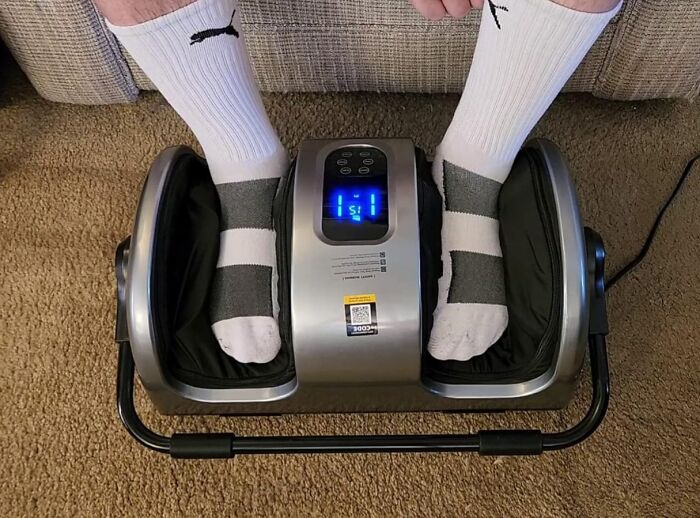 Feet in socks using an under-the-radar foot massager, one of the top under-the-radar finds people loved.