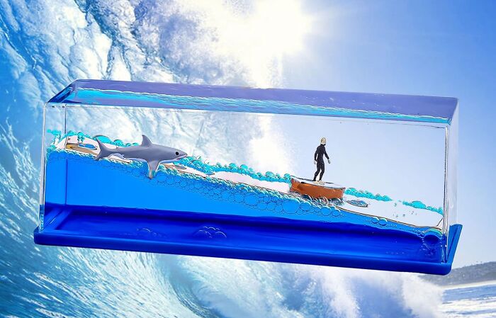 Desk ocean wave paperweight with surfer, shark, and blue water bubbles, adding a low-key holiday destination vibe.