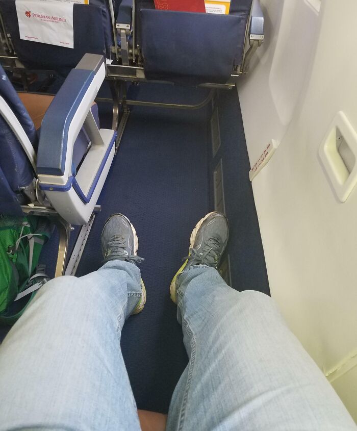 Person enjoying extra legroom on an airplane seat, showcasing unbelievable luck and comfort during travel.