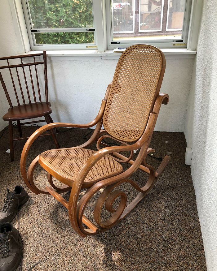 Vintage wooden rocking chair with woven cane seat and backrest placed indoors near window, showcasing amazing luck find.
