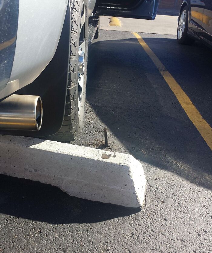 Car tire dangerously close to a nail in asphalt, showcasing unbelievable luck in avoiding a flat tire incident.