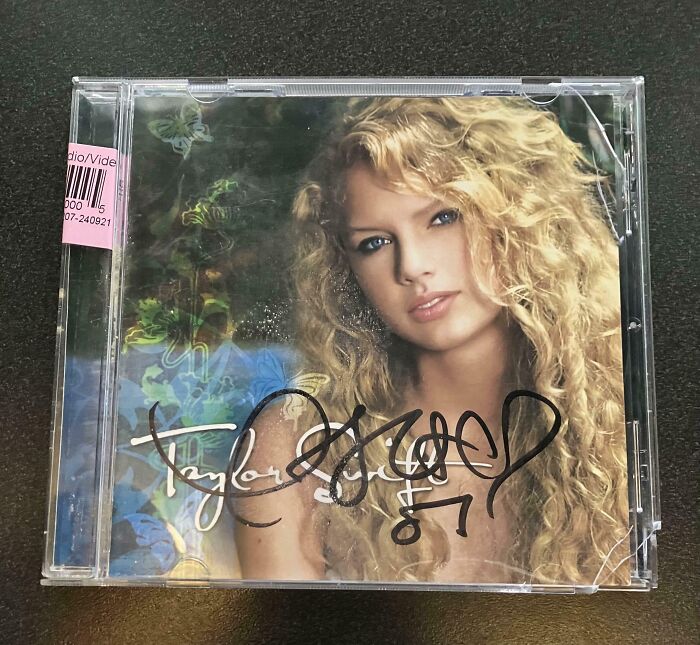 Autographed Taylor Swift CD case, an amazing photo of people experiencing unbelievable luck with rare memorabilia.