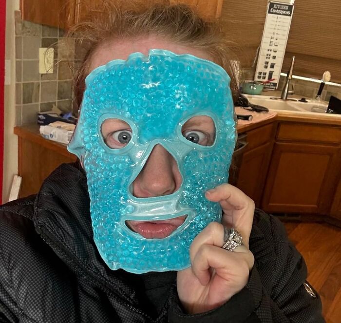 Person wearing a blue gel face mask as a heatwave hack for cooling down during hot summer days indoors.