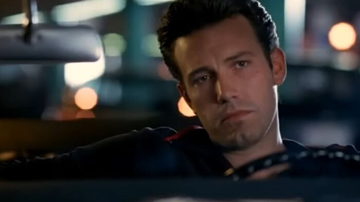 Man sitting in a car at night with a serious face, representing scenes from worst movies of all time.