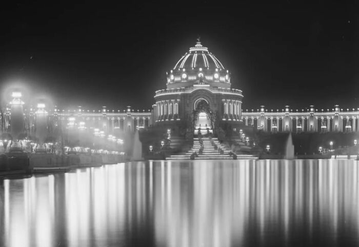 Illuminated old architecture at night reflected in calm water, showcasing the beauty of historical design and craftsmanship.