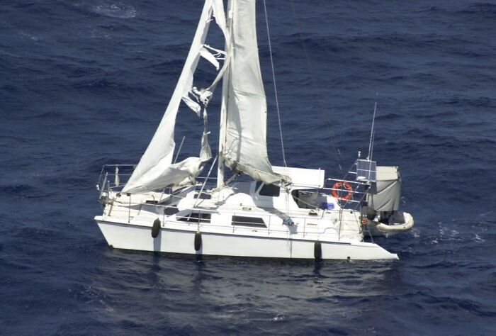 Sailboat with torn sails drifting on calm water, illustrating one of the most interesting mysteries still baffling people.