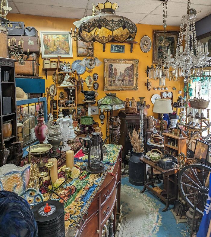 Antique shop filled with a variety of interesting and beautiful old things including lamps, paintings, and vintage decor items.