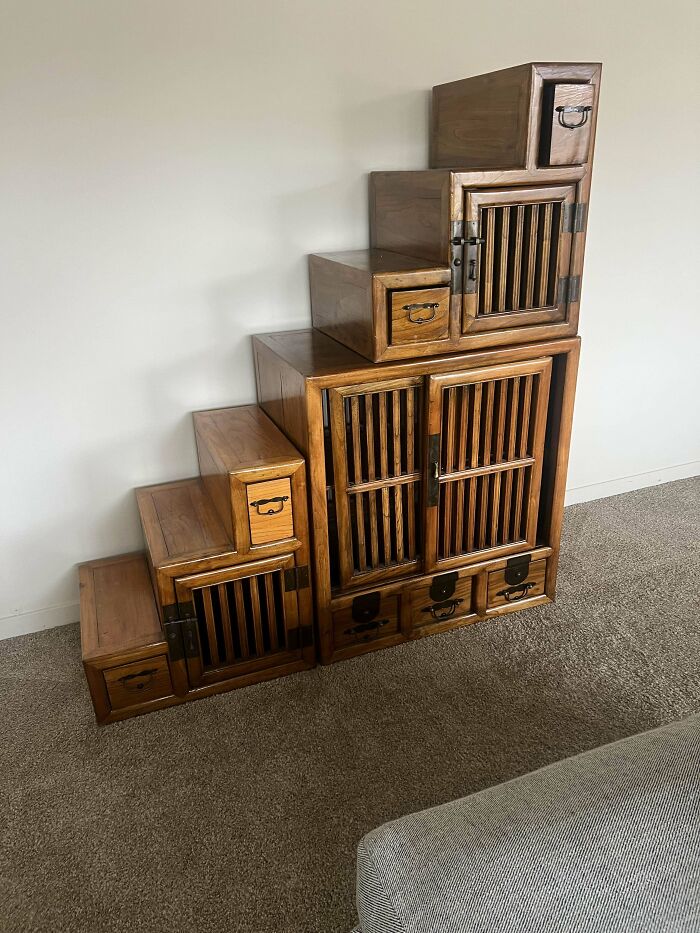 Vintage wooden step cabinet with multiple drawers and slatted doors, showcasing beautiful old things people enjoy owning.