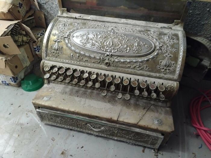 Ornate antique cash register with intricate floral engravings, showcasing beautiful old collectible craftsmanship and design.