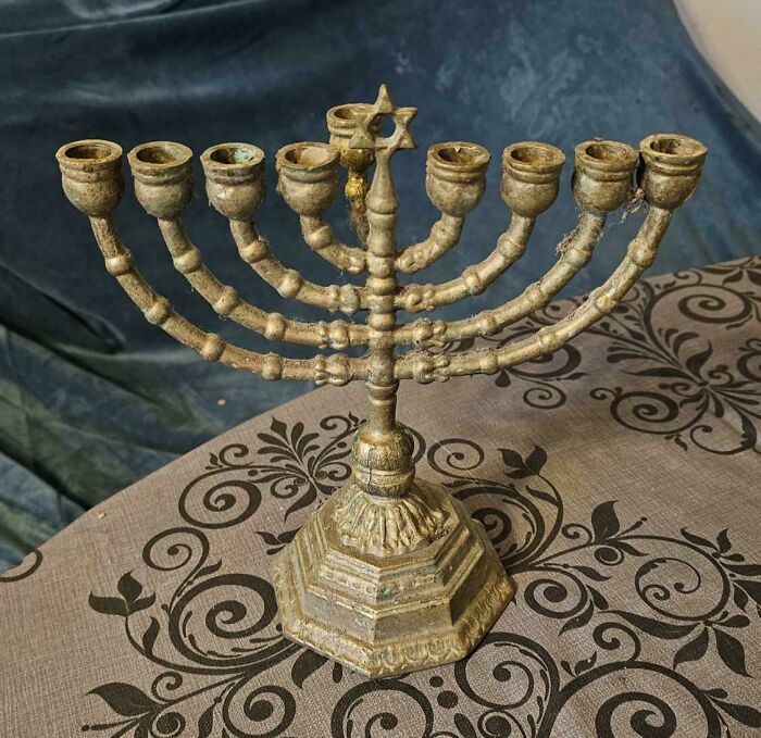 Antique brass menorah with Star of David, an interesting and beautiful old item on a decorative tablecloth.