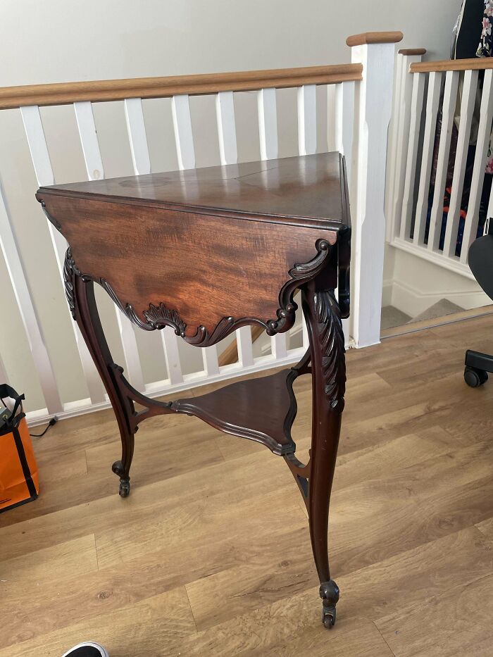 Antique wooden table with intricate carved details and elegant curved legs, showcasing beautiful old craftsmanship.