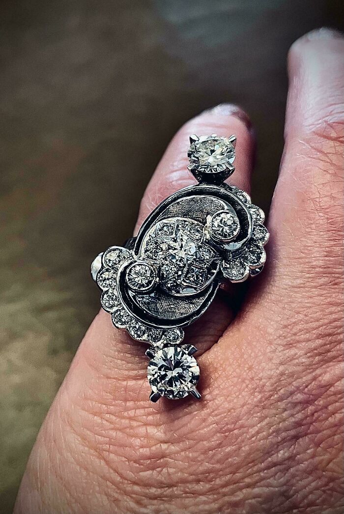 Close-up of a hand wearing a beautiful old vintage diamond ring showcasing intricate design and craftsmanship.
