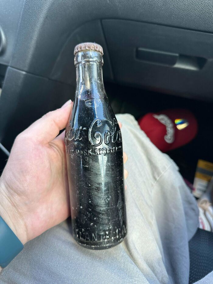 Hand holding an old vintage Coca-Cola glass bottle, showcasing a beautiful and interesting collectible item.