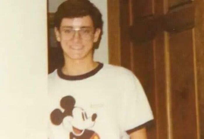Young man wearing glasses and a Mickey Mouse shirt standing indoors, representing interesting mysteries that still baffle people.