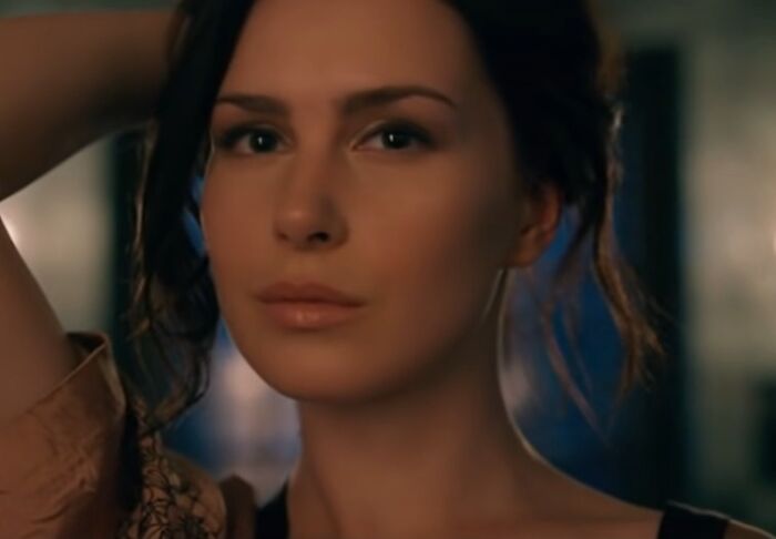 Close-up of a woman with a serious expression in a cinematic scene related to cinematic crimes and movie sequels.