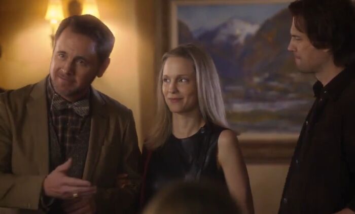 Three people in a dimly lit room, appearing in a scene from one of the worst movie sequels cinematic crimes.