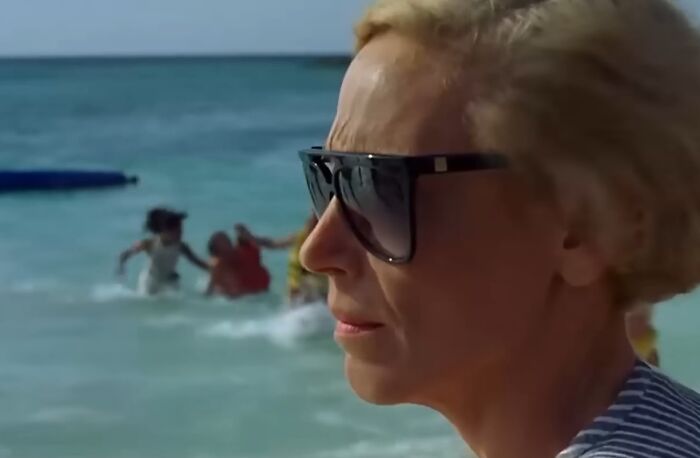 Close-up of a woman wearing dark sunglasses by the sea, illustrating cinematic crimes in the worst movie sequels.