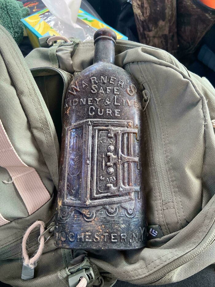 Antique Warner's Safe Kidney and Liver Cure bottle from Rochester NY, a beautiful old collectible item on a backpack.