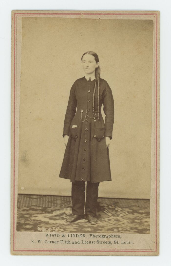 Vintage sepia photo of a woman wearing an old-fashioned dress, one of the most interesting and beautiful old things owned.