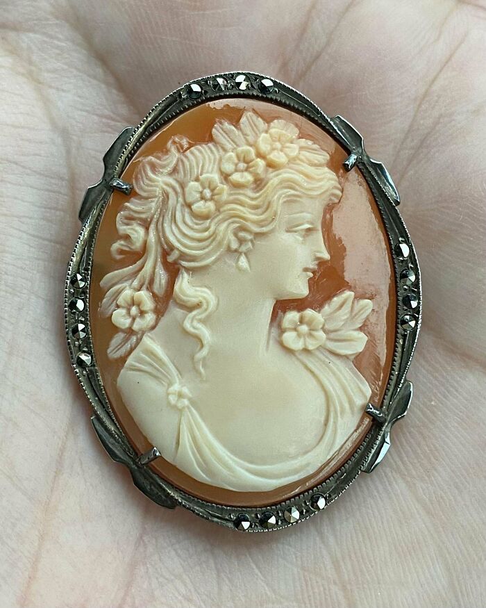Intricately carved vintage cameo brooch with floral details, showcasing one of the most beautiful old things people own.