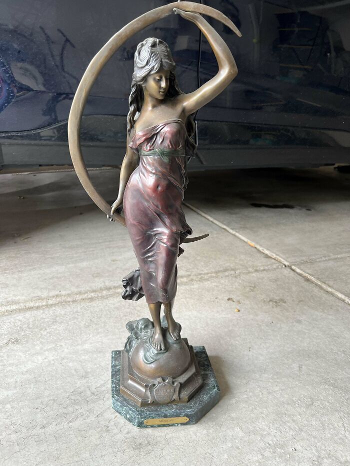 Bronze statue of a woman holding a crescent moon on a decorative base, a beautiful old collectible item.