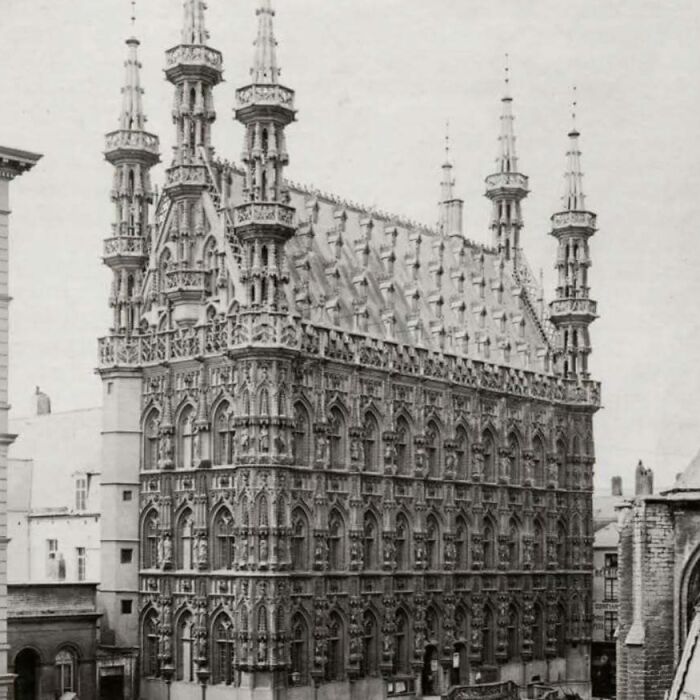 Detailed old architecture building with ornate Gothic-style spires and intricate stone carvings in a historic urban setting.