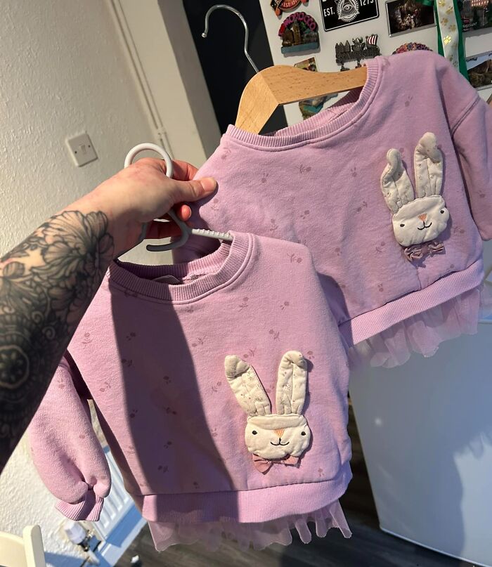 Two identical pink bunny sweatshirts on hangers showing a real-life glitch in the matrix moment with duplicated clothing.