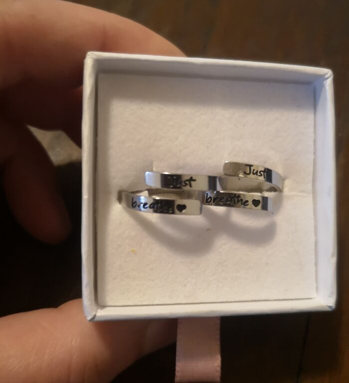 Two matching silver rings with the text just breathe and heart symbol in a white box glitch in the matrix glimpse