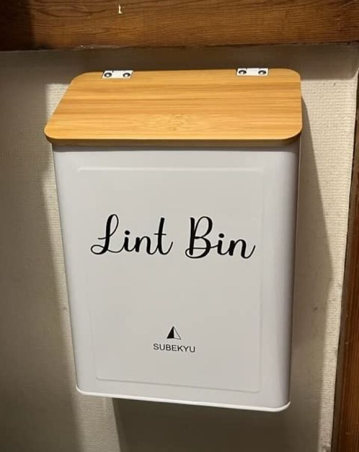 Wall-mounted lint bin with wooden lid designed for convenient and useful laundry room organization.