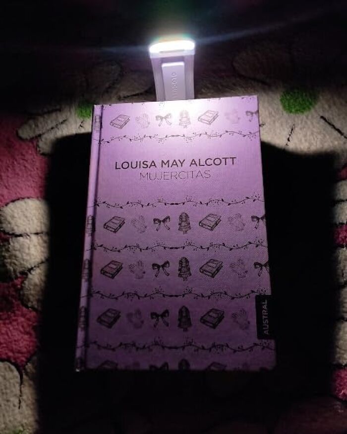 Portable clip-on LED light illuminating a book, showcasing random things that have unexpected useful features.