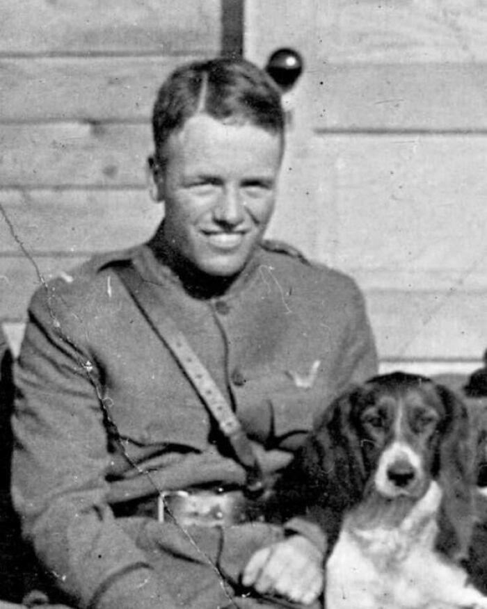 Black and white photo of a soldier sitting with a dog, illustrating unusual and cool world facts about history and animals.