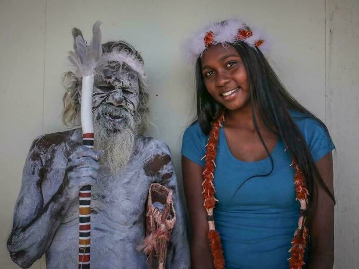 Indigenous elder covered in traditional paint and a young woman wearing cultural attire, representing unusual world facts.