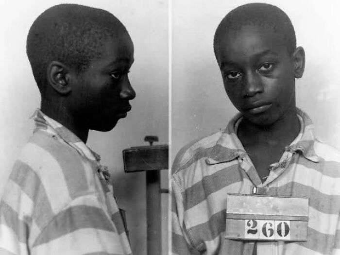 Black and white mugshot of a young boy in striped prison clothes, representing unusual and cool world facts.
