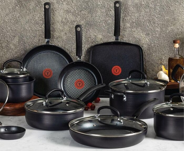Set of black nonstick cookware pans and pots with glass lids displayed on a kitchen counter, highlighting infomercial finds.