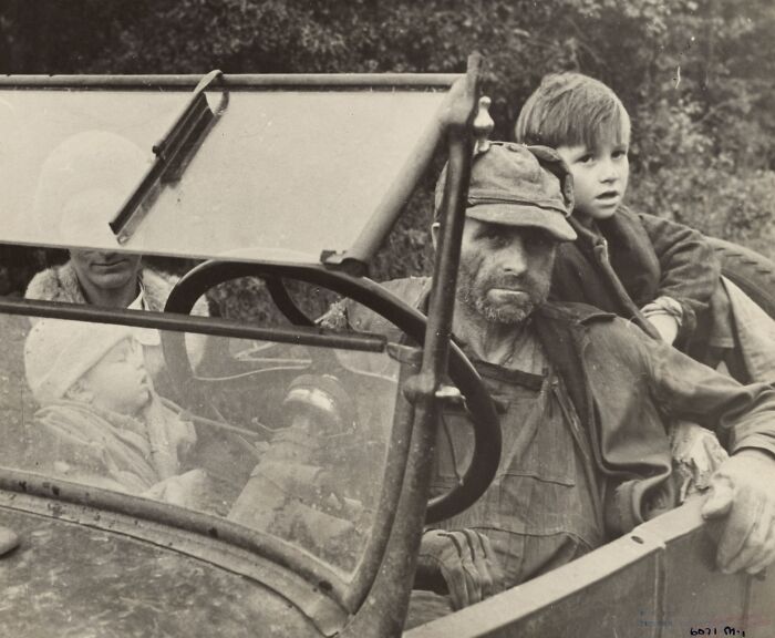 Man and children in a vintage car during the Great Depression era, showing rare photos that bring the period to life.